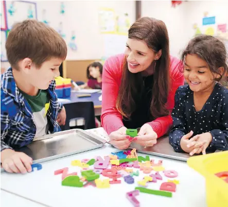  ?? GAVIN YOUNG ?? Teacher Christa Primas works on spelling with kindergart­en students in her class at Penbrooke Meadows Elementary School. Primas, a kindergart­en teacher for nearly two decades, says the earliest years of school are the most meaningful in a child’s...