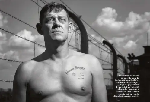  ??  ?? Rainer Höss devant les barbelés du camp de Buchenwald, en juillet 2014, pour la série « Mischlinge », du photograph­e Marc Erwin Babej, sur l’identité allemande. Les numéros tatoués sur son torse sont ceux de trois survivants d’Auschwitz devenus ses amis.