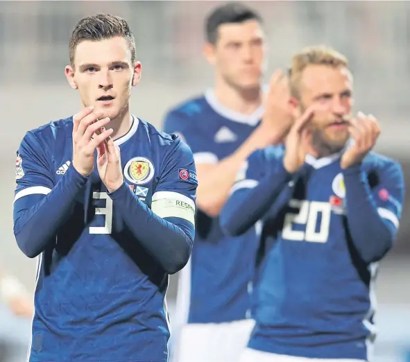  ?? PA. ?? Scotland captain Andy Robertson, left, and team-mates Scott McKenna and Johnny Russell acknowledg­e the fans after the final whistle.