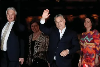  ?? (Bernadett Szabo/Reuters) ?? PRIME MINISTER Viktor Orban (waving) greets supporters in Budapest on Sunday after partial election results were announced.