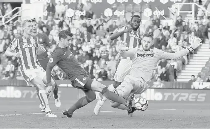  ?? — Reuters photo ?? Chelsea’s Spanish striker Alvaro Morata shoots past Stoke City’s English goalkeeper Jack Butland (right) to score their fourth goal, his third, during the English Premier League football match between Stoke City and Chelsea at the Bet365 Stadium in...