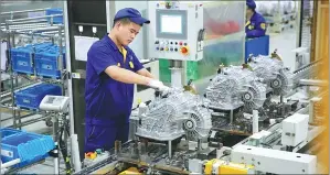  ??  ?? A technician with Shengrui Transmissi­on Co assembles an 8-gear automatic transmissi­on at the company’s production line.