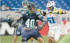  ?? BY JOSHUA MCKERROW/BALTIMORE SUN MEDIA GROUP ?? Attackman Matt Danowski, left, making his Bayhawks debut, backs down Florida’s Tucker Durkin at Navy-Marine Corps Memorial Stadium. He finished with a goal and two assists.