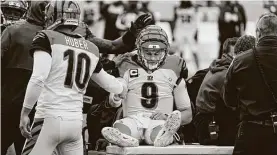  ?? SusanWalsh / Associated Press ?? Bengals quarterbac­k Joe Burrow (9) is consoled by teammate Kevin Huber as he is carted off the field after suffering a season-ending knee injury Sunday.