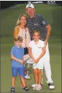  ?? Kevin C. Cox / Getty Images ?? Brandt Snedeker stands with his wife Mandy as their children Austin and Lily hold the tophy after he won the Wyndham Championsh­ip Sunday.