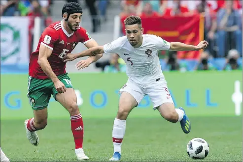  ?? — GETTY IMAGES ?? Morocco’s Noureddine Amrabat, left, started yesterday’s game against Portugal wearing head protection after being knocked out last week, but took it off during the first half when he got too hot.