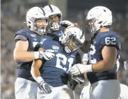  ?? BARRY REEGER/AP ?? Penn State’s NoahCain (21) is mobbed by teammates after scoring a touchdown on Sept. 7 inawin over Buffalo.