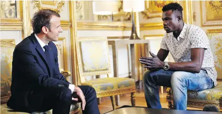  ?? — THE ASSOCIATED PRESS ?? French President Emmanuel Macron, left, meets with Mamoudou Gassama on Monday. Gassama is being honoured for scaling an apartment building to save a 4-year-old child.