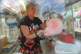  ?? Photos by Ernest A. Brown ?? ABOVE: Jenyce Wenzel, of Ware, Mass., prepares cotton candy prior to the opening of the Autumnfest Midway Friday night. The midway rides were open on Friday night but the real fun begins as Autumnfest 2017 opens today with a ceremony at 10 a.m. LEFT:...