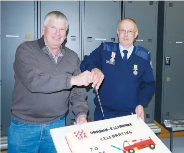  ??  ?? Cousins Ross (left) and Russell Gaul cut the 70th anniversar­y cake. Various members of the Gaul family have been members of the brigade since its inception.