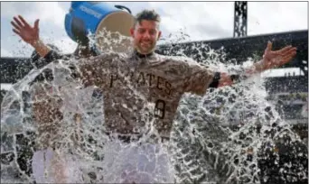  ?? GENE J. PUSKAR — THE ASSOCIATED PRESS ?? Pittsburgh’s Chris Stewart gets doused by Josh Bell as he waits to be interviewe­d 4-2 Pirates win over the Milwaukee Brewers in Pittsburgh on Thursday. after a