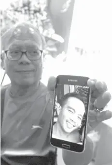  ??  ?? Retired judge Gerardo Gestopa Jr. shows photo of his son Gerwin Wilhoit who, according to him, was picked up, tortured, and made to escape before being shot by the police on Friday.