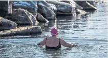  ??  ?? Mcdonnell wades into the water at Ward's Island. Since the early days of COVID-19 lockdown, retailers of wetsuits and other cold-water gear report big growth in sales.