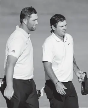  ?? Kevin C. Cox, Getty Images ?? Patrick Reed, right, and Jon Rahm leave the 18th green Saturday after the third round of the Northern Trust in Jersey City, N.J. Reed leads the tournament, and Rahm is two strokes back.