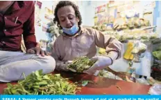  ?? — AFP ?? SANAA: A Yemeni vendor sorts through leaves of qat at a market in the capital on Friday.