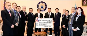  ??  ?? Shafie receiving the RM6 million dividend payment from Ramlee at the State Legislativ­e Assembly building on Monday.