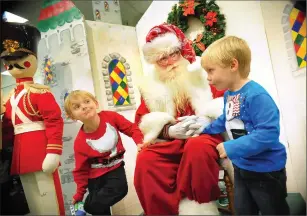  ?? File photo by Ernest A. Brown ?? In this file photo from 2013, Boston Paquette, left, and his brother Chance, both of Lincoln, visit with Brady White as Santa at the Apex outlet store in Pawtucket. White will be back at Apex this Saturday, from noon to 2 p.m., with proceeds from...