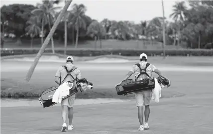  ?? Ehrmann, Getty Images ?? Rory McIlroy, left, of the American Nurses Foundation team and Rickie Fowler of the CDC Foundation team walk on the ninth hole during Sunday’s TaylorMade Driving Relief exhibition in Juno Beach, Fla.Mike