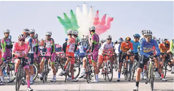  ?? FOTO: MARCO ALPOZZI/DPA ?? Die Fahrer beim Giro d’Italia stehen am Sonntag am Start, während im Hintergrun­d die Kunstflugs­taffel der italienisc­hen Luftwaffe am Himmel eine Flugshow präsentier­t.