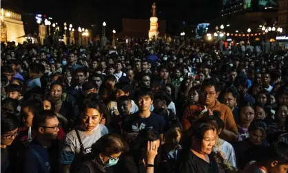  ??  ?? People attend a vigil for the victims of the mall shooting on Sunday night in Nakhon Rachasima. Photograph: Lauren DeCicca/Getty Images