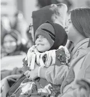  ?? Jon Shapley photos / Houston Chronicle ?? Left: Heidi Mitchell, left, and her friend Dahnya Gianpietro, right, laugh as Mitchell’s son Wyatt, 3, tries to “peck” her with his turkey hat. Right: Iker Delgado, 3, and his cousin, Destiny Christian, await the start of the parade.