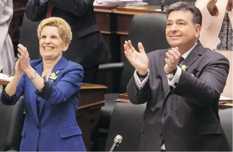  ?? THE CANADIAN PRESS ?? Premier Kathleen Wynne and Finance Minister Charles Sousa applaud the 2018 Budget at Queen’s Park on Wednesday. Sousa insisted “it’s time for a different approach” in unveiling a plan that spends billions more for everything from prescripti­on drugs to...