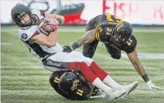  ?? SCOTT GARDNER THE HAMILTON SPECTATOR ?? Ottawa Redblacks wide receiver Greg Ellington is downed by Hamilton Tiger-Cats Larry Dean (11) and Simoni Lawrence during Canadian Football League action at Tim Hortons Field on Saturday afternoon.