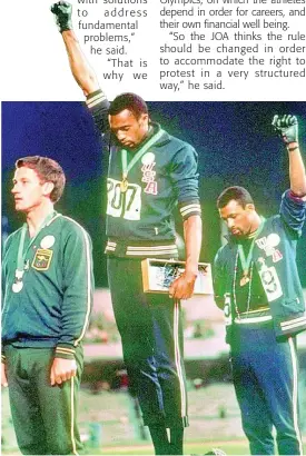  ?? FILE ?? In this file photo from October 1968, United States athletes Tommie Smith (center) and John Carlos (right) stare downward while extending gloved hands skyward during the playing of the American national anthem after Smith received the gold, and Carlos the bronze medal, for the men’s 200m sprint at the Summer Olympic Games in Mexico City, Mexico. Australian silver medalist Peter Norman is at left. The Americans were using their internatio­nal platform to protest for black civil rights back home.