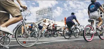  ??  ?? BICYCLISTS PEDAL along Wilshire Boulevard near MacArthur Park, one of the celebratio­n’s musical stops.