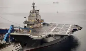  ?? REUTERS ?? CHINA’S first aircraft carrier, which was renovated from an old aircraft carrier that China bought from Ukraine in 1998, is seen docked at Dalian Port in Dalian, Liaoning province, in this September 2012 file photo.