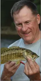  ?? (Arkansas Democrat-Gazette/Bryan Hendricks) ?? Bill Eldridge of Benton admires a smallmouth bass he caught last Sunday on the Buffalo River between Spring Creek and Rush.