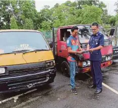  ??  ?? MOHD Othman (kiri) berbincang dengan pegawai JPJ selepas memenangi bidaan dalam acara lelongan awam, semalam.