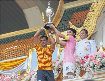  ??  ?? Thammasat captain Siva Thanusorn, left, and his Chulalongk­orn counterpar­t lift the trophy at the end of yesterday’s match.