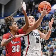  ?? Jessica Hill/Associated Press ?? UConn’s Nika Muhl goes up to the basket as St. John’s Kadaja Bailey defends on Tuesday.