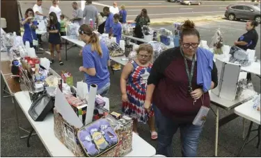  ?? BEN HASTY - MEDIANEWS GROUP ?? Attendees survey raffle items during a fundraiser for Melissa Dawson at the Rita’s in Mount Penn Thursday. Dawson, 48, is the lone survivor of a car crash that killed her husband and two children in North Carolina earlier this month.