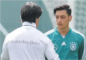  ?? AFP ?? Joachim Low talks to Mesut Ozil during a training session in Vatutinki