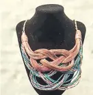 ??  ?? Collar de finos cables en diferentes tonos trabajado con centro de flor de tapitas de plástico fundidas. Una obra de Génesis Benítez.
