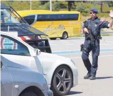  ??  ?? Spanish police officers control vehicles as they cross the Spanish-French border