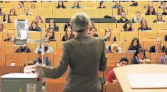  ??  ?? Eine Professori­n hält in einem Hörsaal der Ruhr-Universitä­t in Bochum eine Vorlesung der Amerikanis­tik.