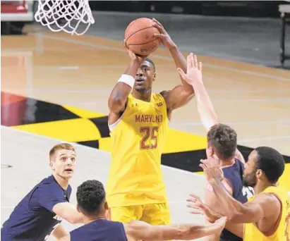  ?? PHOTOS BY KARL MERTON FERRON/THE BALTIMORE SUN ?? Maryland forward Jairus Hamilton goes up for a shot as three Navy defenders can only watch helplessly Friday in College Park.