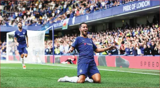  ??  ?? Hazard celebrates after one of his three goals that sent Chelsea top