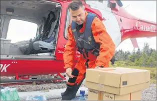  ?? ADAM RANDELL/THE CENTRAL VOICE ?? Canadian Coast Guard pilot Brad Marshall helps load supplies for Puffin Island. A large portion of the supply run includes drinking water, as aside from rain collection, the site has no dedicated fresh water source.