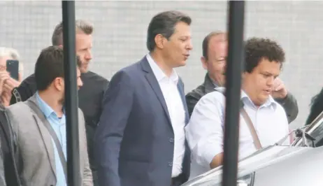  ??  ?? El candidato Fernando Haddad (centro), deja la Superinten­dencia de la Policía Federal tras visitar al ex presidente Luiz Inácio Lula da Silva, preso en el lugar.