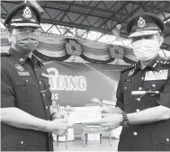  ?? — Gambar Bernama ?? TERIMALAH: Abdul Majid (kanan) menyampaik­an sumbangan Tabung Amanah Perwira dan Pertahanan Negara (TAPPN) kepada DSP Mohamad Hasnal Jamil sempena sambutan peringatan Hari Polis ke-214 Kontinjen Melaka di Ayer Keroh, di Melaka semalam. Mohamad Hasnal antara pegawai yang terselamat ketika insiden serangan hendap penceroboh dari selatan Filipina di Kampung Simunul, Semporna, Sabah pada 2 Mac 2013 dalam Ops Daulat.