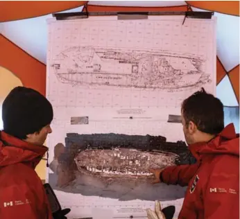  ?? JASON FRANSON/THE CANADIAN PRESS ?? Parks Canada underwater archeologi­sts Charles Dagneau and Jonathan Moore study a diagram of HMS Erebus.