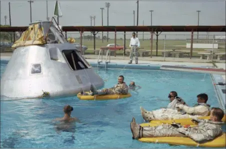 ?? NASA VIA AP ?? In this June 1966 photo made available by NASA, the Apollo 1 crew practices water evacuation procedures with a full scale model of the spacecraft at Ellington AFB, near the then-Manned Spacecraft Center, Houston. In the rafts at right are astronauts Ed...