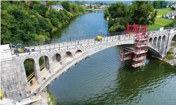  ?? Foto: Vögele/Landratsam­t ?? Die historisch­e Bahnbrücke zwischen Lautrach und Illerbeure­n wird derzeit saniert. Der linke Teil des Bogens (bis zum Hängege rüst) ist bereits fertig. Rechts im Bild ist noch der alte Zustand zu sehen. Im Hintergrun­d sieht man die Illerbrück­e, die der Land kreis im Jahr 2010 neu gebaut hat.