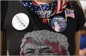  ?? MADDIE MCGARVEY — THE NEW YORK TIMES ?? An attendee at Donald Trump's rally at a county fairground in Wellington, Ohio, shows off the merchandis­e on June 26.