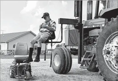  ?? ANDREW SOREGEL/AP ?? Farmer Mark Hosier, who is paralyzed from the waist down, uses a lift to get into a tractor on his Alexandria, Indiana, farm.