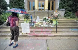  ?? AARON LAVINSKY/AP ?? A woman visits a memorial for Justine Damond at a south Minneapoli­s church.